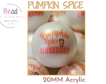 May include: A round white 20mm acrylic bead featuring the orange text Pumpkin Spice OBSESSED and a small coffee cup graphic. The bead has a smooth finish and is part of a collection of identical beads shown in the image.