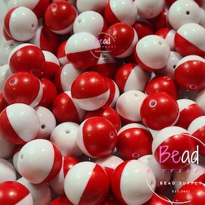 May include: A pile of red and white acrylic beads. The beads are round with a hole through the center. Some beads are solid red, while others are half red and half white. The word "Acrylic" is written vertically on the left side of the image.