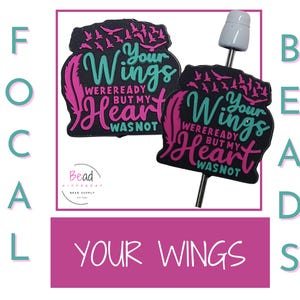 May include: Two black and pink charm beads with the text "Your Wings Were Ready But My Heart Was Not" in teal and pink lettering. The beads are attached to a silver metal stick.
