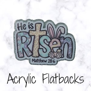 May include: An acrylic flatback with a glittery border, featuring the words "He is Risen" with a cross and bunny ears. The text "Matthew 28:6" is also included. The flatback has a pastel colour scheme.