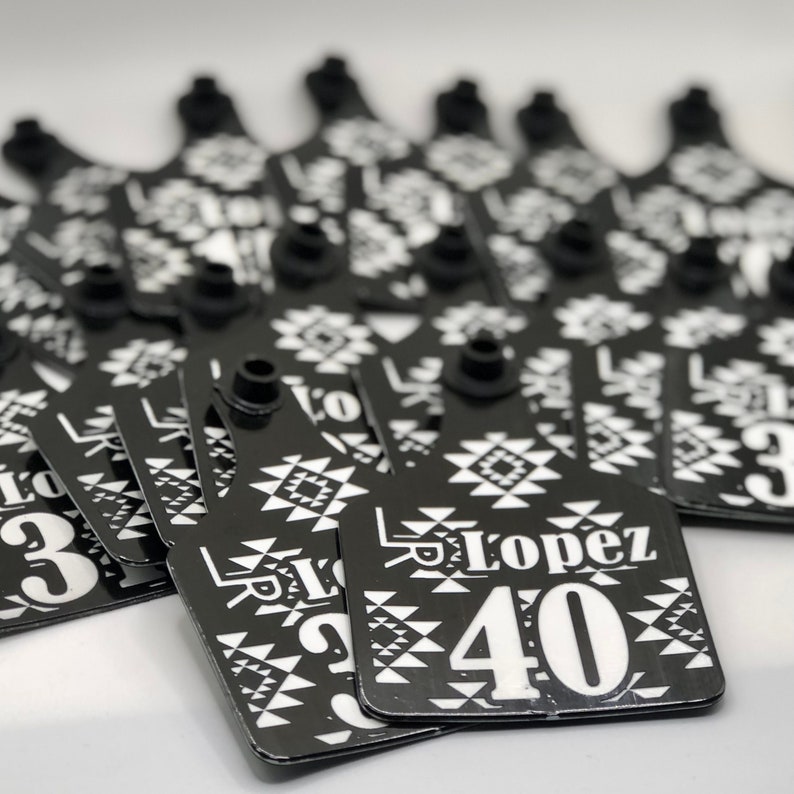 May include: Black and white patterned plastic tags with a white number and name. The tag reads "Lopez 40".