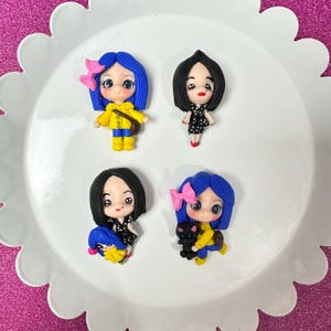 May include: Four handmade polymer clay doll charms. Each doll has blue hair, a yellow dress, and a black cat. The dolls are wearing different accessories, including a yellow raincoat, a black dress, and a pink bow.