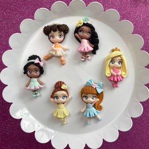 May include: Set of seven colorful ballerina figurines with different hair styles and outfits. The figurines are made of polymer clay and have painted details.