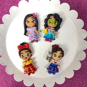 May include: Four handmade polymer clay dolls with colorful clothing and hair. The dolls are wearing traditional Mexican clothing and have different hairstyles.