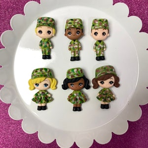 May include: Set of eight miniature figurines of children wearing camouflage hats and outfits. The figurines are made of polymer clay and are painted in shades of green, brown, and yellow.