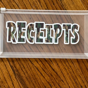 May include: Clear plastic zippered pouch with a camouflage pattern sticker that says "RECEIPTS".