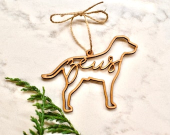 May include: Wooden dog-shaped Christmas ornament with the name "Zeus" cut out inside the silhouette.