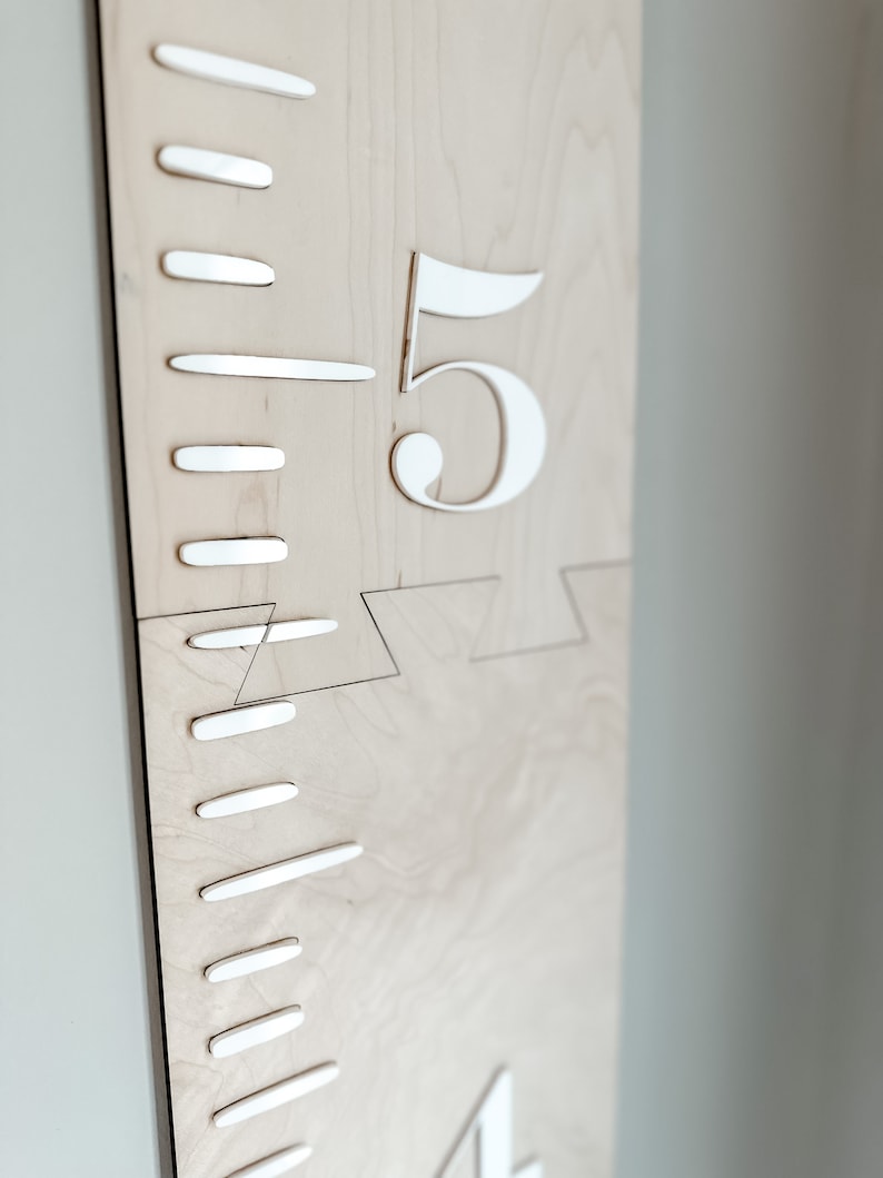 May include: A wooden growth chart with white numbers and markings. The number "5" is visible on the chart.
