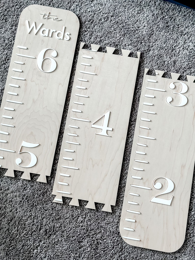 May include: Three wooden growth charts with a scalloped edge. The charts are labeled with the numbers 2, 3, 4, 5, and 6. The top chart also has the text "the Wards" on it.