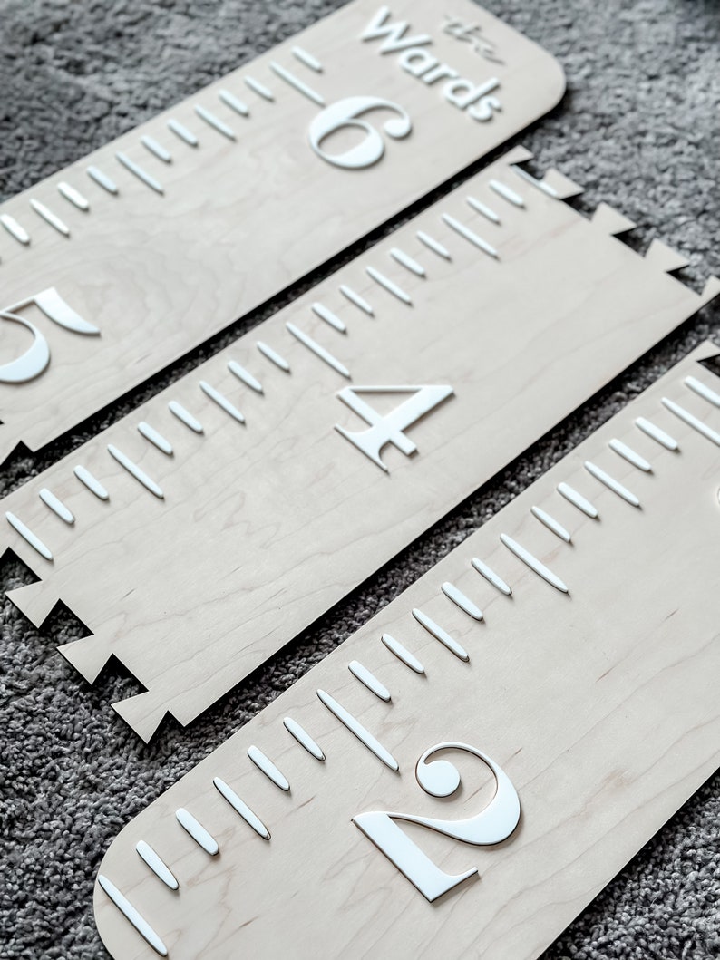 May include: Three wooden growth charts with white numbers and markings. The charts are labeled "2", "4", and "6" with the text "the Wards" on the top chart.