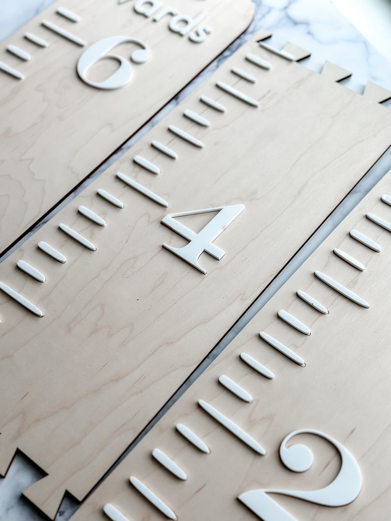 May include: Three wooden growth charts with white numbers and markings. The charts are labeled "6 yards", "4 yards", and "2 yards".