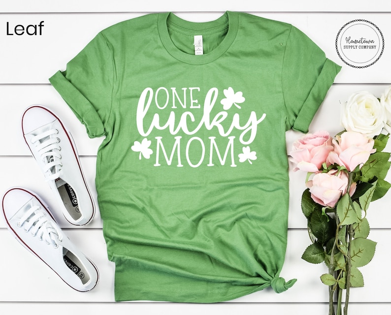 May include: Green t-shirt with white text that says "One lucky mom" and shamrock designs.