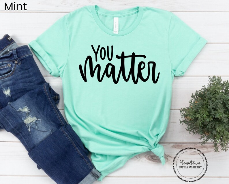 May include: A mint green t-shirt with the text "You Matter" in black lettering.