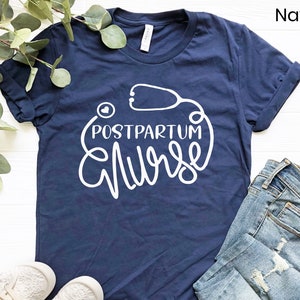 May include: Navy blue t-shirt with white text that reads "Postpartum Nurse" with a stethoscope graphic.