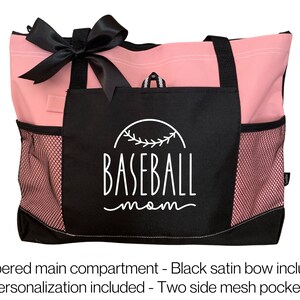 Może przedstawiać: R&oacute;żowa i czarna torba typu tote z czarną satynową kokardką. Torba ma czarną kieszeń z napisem "BASEBALL mom" w kolorze białym. Torba ma dwie boczne kieszenie siatkowe.