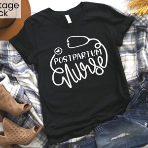 May include: Black t-shirt with white text that reads "Postpartum Nurse" and a stethoscope graphic.