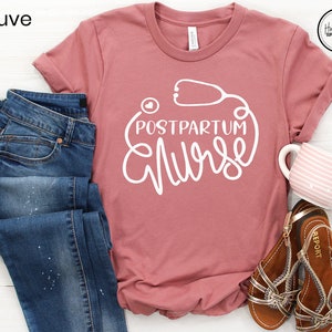 May include: Mauve t-shirt with a white graphic of a stethoscope and the text "Postpartum Nurse".