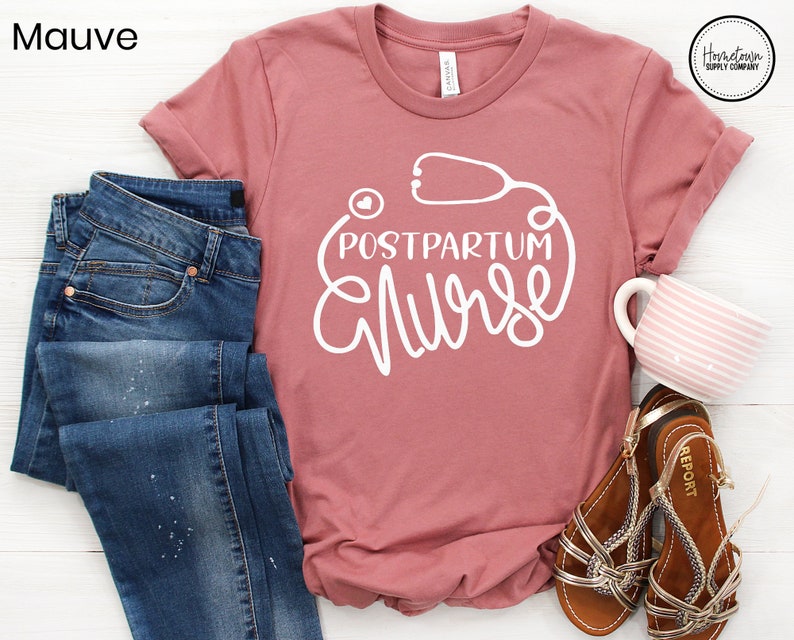 May include: Mauve t-shirt with a white graphic of a stethoscope and the text "Postpartum Nurse".