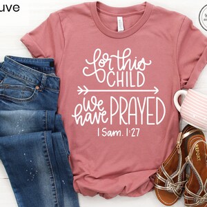 K&ouml;nnte beinhalten: Mauvefarbenes T-Shirt mit dem Text "For this child we have prayed I Sam. 1:27" in wei&szlig;en Buchstaben.