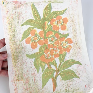 May include: A vintage print of a floral design with orange flowers and green leaves on a white background with a textured pattern.