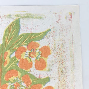 May include: A vintage floral print with orange and yellow flowers on a white background. The print features a green leafy design and a textured, speckled background.