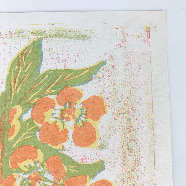 May include: A vintage floral print with orange and yellow flowers on a white background. The print features a green leafy design and a textured, speckled background.