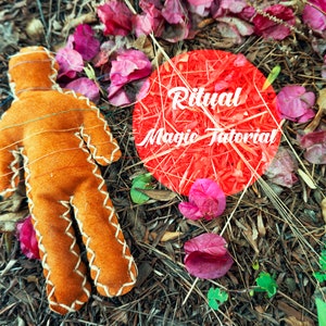 May include: An orange felt doll with white stitching, lying on a bed of leaves and twigs. The doll is in a human shape. A red circle with the words "Ritual Magic Tutorial" is in the background.