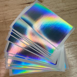 May include: A set of three ceramic mugs with a speckled, matte finish. The mugs are in shades of cream, light gray, and dark gray. Each mug has a simple, minimalist design, perfect for coffee or tea.