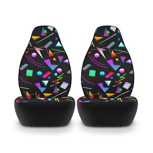Puede incluir: Dos fundas de asiento de coche negras con un patr&oacute;n geom&eacute;trico en colores brillantes, incluyendo rosa, azul, verde, amarillo y naranja. El patr&oacute;n est&aacute; sobre un fondo negro.