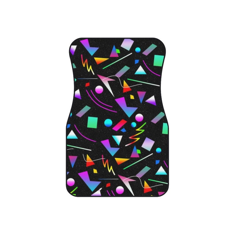 Op de afbeelding: Een zwarte autovloermat met een geometrisch patroon in neonkleuren, waaronder roze, blauw, groen en geel.