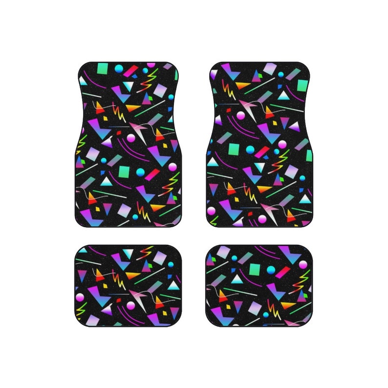 Op de afbeelding: Set van vier zwarte autovloermatten met een geometrisch patroon in felle kleuren, waaronder roze, blauw, groen, geel en oranje.