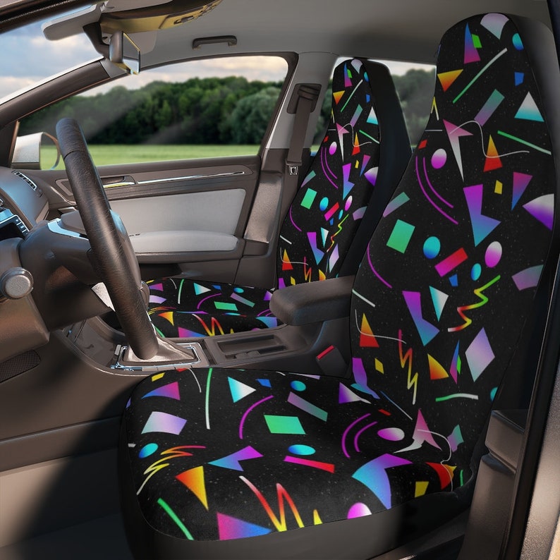 Puede incluir: Un par de fundas para asientos de coche con un patr&oacute;n geom&eacute;trico en colores ne&oacute;n sobre un fondo negro. El patr&oacute;n incluye c&iacute;rculos, cuadrados, tri&aacute;ngulos y l&iacute;neas.