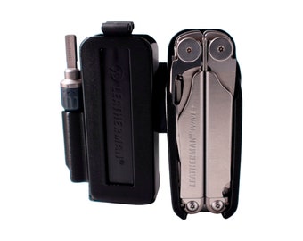 May include: A black Leatherman Wave+ multi-tool with a silver finish, in a black plastic case. The case has a belt loop and the multi-tool has a screwdriver bit attached.