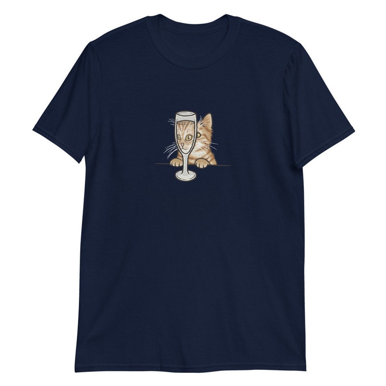 May include: A navy blue t-shirt with a graphic of a cat peeking out from behind a champagne glass.