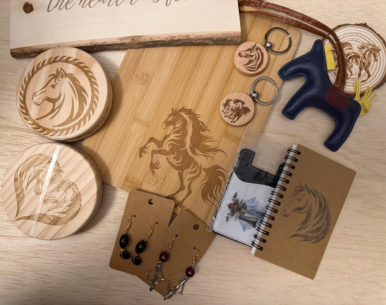 May include: A collection of horse-themed items, including wooden coasters, a cutting board, keychains, a leather horse figurine, earrings, a notebook, and a cardholder. The items feature engraved horse designs and are arranged on a light wooden surface.