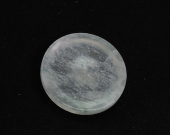 May include: A round, white jade pendant with a small hole in the center. The jade has a translucent, cloudy appearance with subtle green streaks.