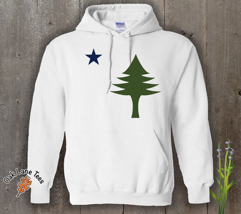 Pu&ograve; includere: Felpa con cappuccio bianca con un pino verde e una stella blu sul davanti. Il testo "Oak Lane Tees" &egrave; sulla manica sinistra.