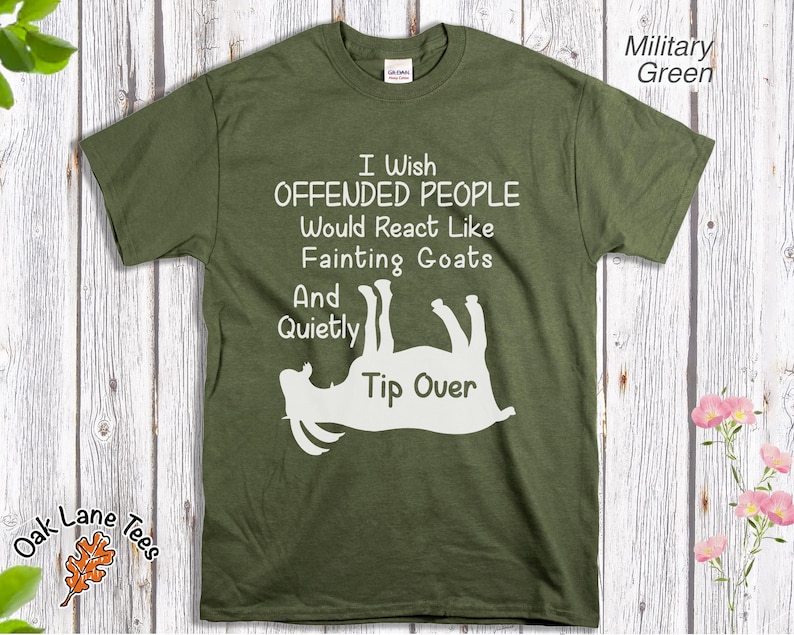 Może przedstawiać: Zielona koszulka w kolorze wojskowym z napisem "I Wish Offended People Would React Like Fainting Goats And Quietly Tip Over" oraz białą grafiką omdlewającej kozy. Koszulka ma okrągły dekolt.