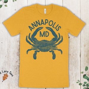 May include: A yellow t-shirt with a blue crab graphic and the text "Annapolis MD".
