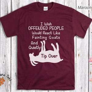 Może przedstawiać: Bordowa koszulka z białym tekstem i grafiką omdlewającej kozy. Tekst brzmi: "I Wish Offended People Would React Like Fainting Goats And Quietly Tip Over."