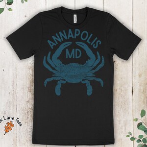 May include: Black t-shirt with a blue crab graphic and the text "ANNAPOLIS MD".
