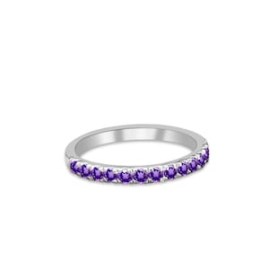 May include: A silver band ring with a row of small purple amethyst gemstones.