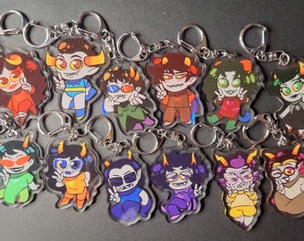 Può includere: Un set di 12 portachiavi con personaggi dei cartoni animati colorati. Ogni portachiavi presenta un personaggio diverso con colori, espressioni e accessori unici. I portachiavi sono realizzati in acrilico trasparente e hanno anelli portachiavi in metallo argentato.