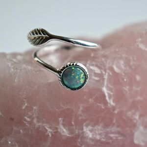 Peut inclure: Une bague en argent avec un motif de feuille et une pierre ronde d'opale verte.