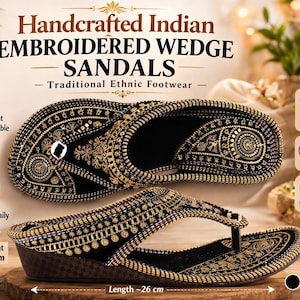 May include: Handcrafted Indian embroidered wedge sandals with a traditional ethnic design. The black sandals feature gold embroidery, a wedge heel, and a cushioned insole. The height is approximately 10 cm, and the length is about 26 cm.