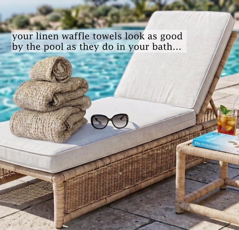 May include: A stack of three beige linen waffle towels, black sunglasses, and a book on a light-colored chaise lounge. The text reads: your linen waffle towels look as good by the pool as they do in your bath...