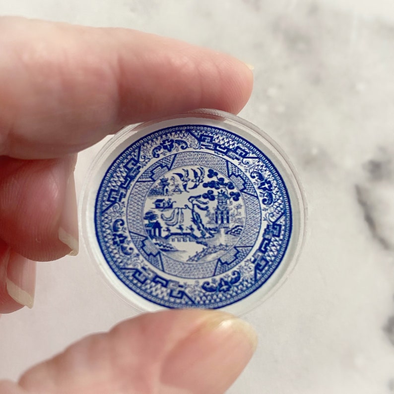 May include: A blue and white ceramic plate with a traditional Chinese design. The plate is round and has a white background with blue floral patterns.