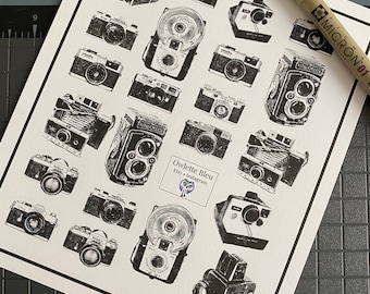 May include: A black and white print of vintage cameras, with the text "Owlette Bleu Etsy + Instagram" at the bottom.