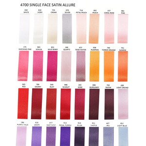 K&ouml;nnte beinhalten: Eine Farbkarte mit Satinbandmustern. Die Karte zeigt eine Vielzahl von Farben, darunter Wei&szlig;, Creme, Rosa, Rot, Lila und Blau. Der Text "4700 SINGLE FACE SATIN ALLURE" steht oben. Die Marke "RELIANT RIBBON" ist ebenfalls sichtbar.