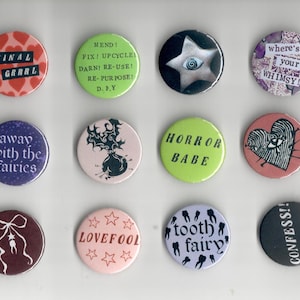 Pu&ograve; includere: Una collezione di dodici bottoni rotondi con vari disegni e testi. I bottoni presentano frasi come "FINAL GRRRL", "HORROR BABE" e "CONFESS!!". Altri bottoni hanno illustrazioni di una stella, un cuore con un occhio e una fatina dei denti.